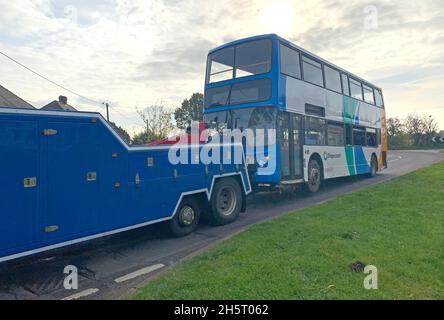 Ein Schulbus wird nach dem Umkippen in Meadow Lane, North Hykeham, in der Nähe von Lincoln abgeschleppt. Die Polizei von Lincolnshire sagte, dass nach dem Unfall keine schweren Verletzungen gemeldet wurden. Bilddatum: Donnerstag, 11. November 2021. Stockfoto