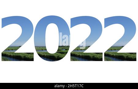 2022 Text für das neue Jahr, Text mit Zahlen gemacht Landschaft mit Gras, Strom und einem blauen Himmel von isoliert auf weißem Hintergrund Stockfoto