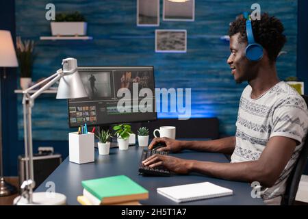afroamerikanischer Videofilmer bearbeitet Videomontage für Visual Effects-Filmprojekt auf Computer. Filmemacher, der fernab von zu Hause mit der digitalen Postproduktionssoftware arbeitet Stockfoto