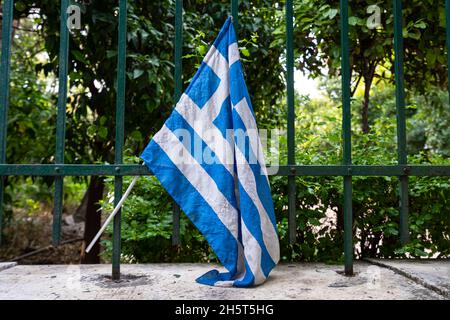 Athen, Griechenland. 2021. November. Eine griechische Flagge auf dem Geländer eines Zauns Stockfoto