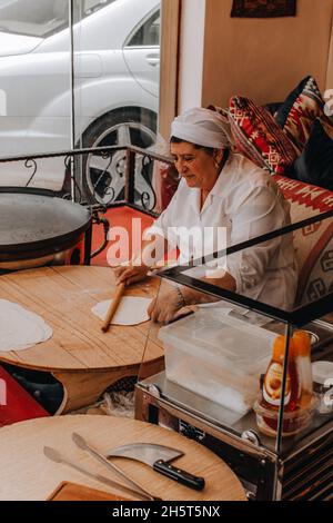 Türkische Frau, die in einem Restaurant traditionelles türkisches Gebäck Gozleme zubereitete. Stockfoto