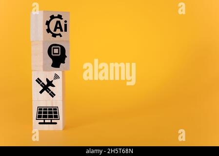 Technologiekonzept mit Ikonen auf Holzwürfeln, gelber Hintergrund. Das Konzept der künstlichen Intelligenz. Stockfoto