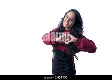 Hübsche lateinamerikanische hispanische Frau mit langen dicken Haaren, die eine Brille auf weißem Hintergrund trägt und dabei Ausdrücke und Gesten macht, glücklich, glücklich, lächelnd, in Stockfoto