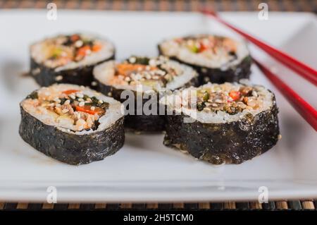 Schneiden Sie Kimbap oder Gimpab. Traditionelle koreanische Brötchen mit Reis, Rindfleisch, Gemüse und Omelette Stockfoto