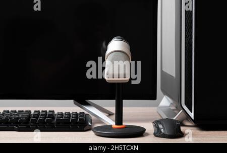 Mikrofon und Computer auf dem Desktop. Arbeitsplatz des Bloggers. Stockfoto