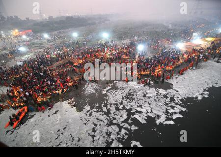 Neu-Delhi, Indien. November 2021. Eifrige Frauen bieten Surya Bhagwan (der Sonnengott steigt auf) während der Feier des Chhat Puja Festivals auf dem Yamuna Fluss Gebete des heiligen Wassers an, trotz der hohen Verschmutzung des Flusses mit giftigem Schaum aufgrund der hohen Aktivität der Fabriken in der Nähe des Ortes, Die lokalen Behörden haben keine Maßnahmen zur Vermeidung von Umweltbelastungen ergriffen. Quelle: Eyepix Group/Alamy Live News Stockfoto