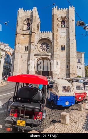 LISSABON, PORTUGAL - 10. OKTOBER 2017: Tuk Tuks vor der Kathedrale Santa Maria Maggiore in Lissabon, Portugal Stockfoto