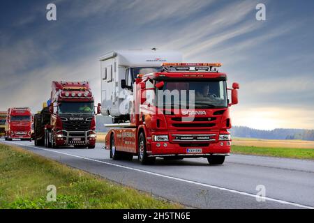 Schwerer LKW-Konvoi zur Power Truck Show mit Scania P-Abschleppwagen Eskola, der zuerst einen Wohnmobil in der Schlange trägt. Luopajarvi, Finnland. 9. August 2018. Stockfoto