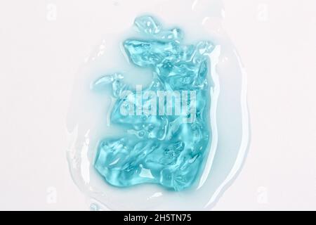Kosmetische Lotion Gel Hintergrund. Kosmetisches Konzept. Flüssiges Gel kosmetische Flecken Tropfen Textur. Flach, Draufsicht. Stockfoto