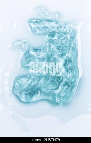 Kosmetische Lotion Gel Hintergrund. Kosmetisches Konzept. Flüssiges Gel kosmetische Flecken Tropfen Textur. Flach, Draufsicht. Stockfoto