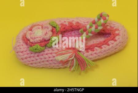 Eine rosa Kinderwollsocke auf gelbem Hintergrund Stockfoto