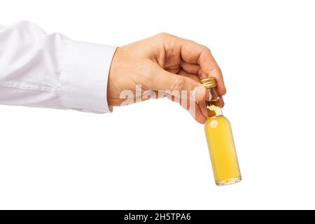 Der Mann hält in der Hand eine kleine Flasche Whisky isoliert auf weißem Hintergrund, Vorlage für Designer Stockfoto