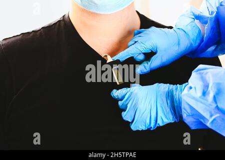 Der Arzt legt einen holter an die Brust des Mannes. Tägliche Überwachung des Herzens. Kardiologie. Stockfoto