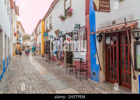 OBIDOS, PORTUGAL - 11. OKTOBER 2017: Touristen in einer engen Gasse im Dorf Obidos. Stockfoto