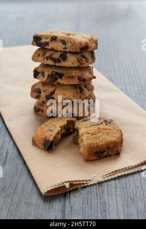 Kekse mit dunklen Schokoladenstückchen auf rustikalem Hintergrund Stockfoto