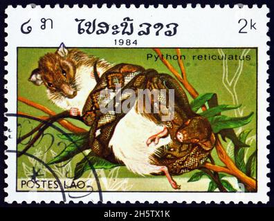 LAOS - UM 1984: Ein Stempel, der in Laos gedruckt wurde, zeigt die Netzpython, Python reticulatus, eine in Südostasien um 1984 vorgefundene Pythonart Stockfoto