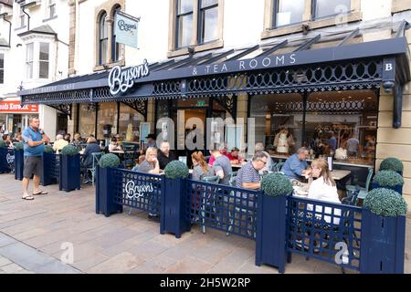 Tea Rooms UK; Personen, die im Sommer draußen sitzen und Tee trinken, Brysons Tea Rooms und Café, Keswick Stadtzentrum, Keswick Cumbria Großbritannien Stockfoto