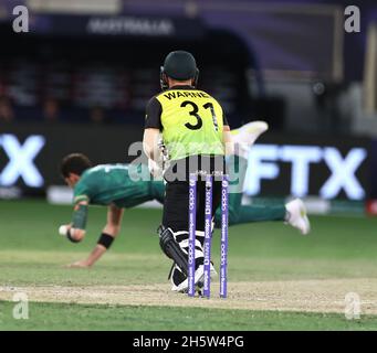 Dubaii, VAE, 11, Nov 2021: ICC T20 2. Halbfinale: Pakistan gegen Australien: Afridi von Pakistan versucht, seinen eigenen Ball vor dem Hit von Warner in Aktion während der 2. Halbzeit im Dubai interraational Stadium am Donnerstag zu stoppen. Bildnachweis: Seshadri SUKUMAR Kredit: Seshadri SUKUMAR/Alamy Live Nachrichten Stockfoto