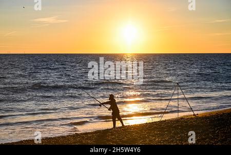 Brighton UK 11. November 2021 - Ein Fischer treibt bei Sonnenuntergang vor den Strand von Brighton ins Meer: Credit Simon Dack / Alamy Live News Stockfoto