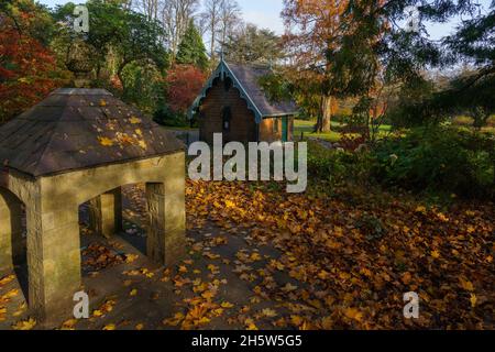 Die Herbstblätter fallen in die Nähe eines renovierten Pumpenraums neben einem Khalybeate-Brunnen Magnesia im Vordergrund, Harrogate, England, Großbritannien. Stockfoto