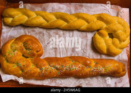 Flache Lay von einem hölzernen Tablett, in dem wir zwei Gaiatos sehen, einer süß und der andere salzig. Dies ist eine traditionelle Süßigkeit des Festivals von San Blas in Torre Stockfoto