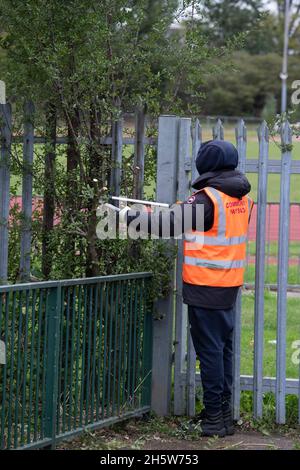 Community Payback Straftäter helfen in der Gemeinschaft durch Aufräumen und Aufräumen von Grünflächen und tun einige diy wie Malerei und Gartenarbeit. Stockfoto