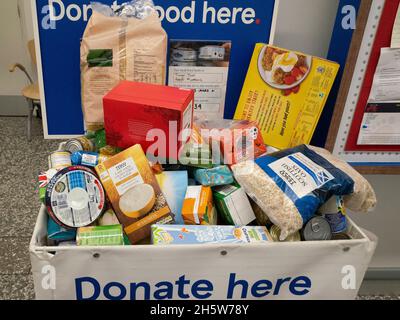 Spenderbox in einem Supermarkt, mit der Kunden Lebensmittel spenden können, die an örtliche Wohltätigkeitsorganisationen der Food Bank für den Vertrieb an Bedürftige gegeben werden Stockfoto