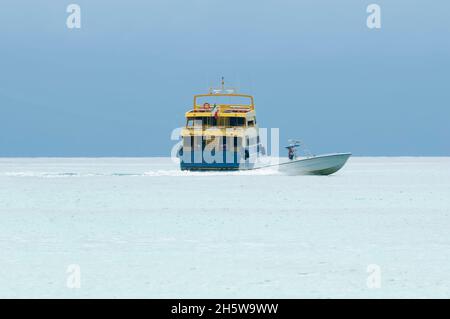 Eine Fähre und ein kleines Schnellboot überqueren die Karibik am Horizont in Mexiko Stockfoto