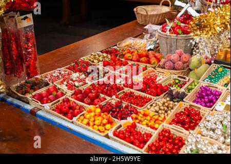 Verkaufsstände des Weihnachtsmarktes in Straßburg, Frankreich. Ein sehr farbenfroher und appetitlich kandierter Obststand. Stockfoto