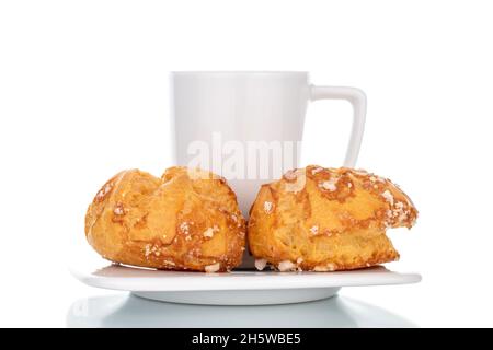 Zwei duftende Chouquette mit Keramikgeschirr, Nahaufnahme, isoliert auf Weiß. Stockfoto