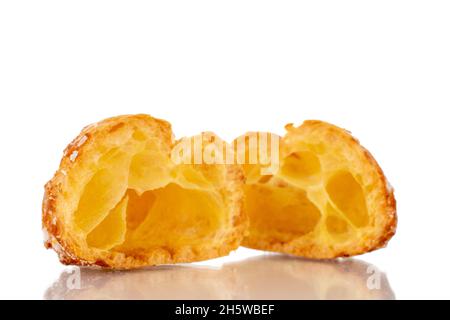 Zwei Hälften einer duftenden Chouquette in einer Glasschale, Nahaufnahme, isoliert auf Weiß. Stockfoto