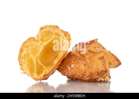 Zwei Hälften einer duftenden Chouquette in einer Glasschale, Nahaufnahme, isoliert auf Weiß. Stockfoto