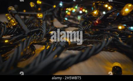 Elektrisch, abstrakt. Weihnachtsgirlande mit bunten Glühbirnen und Leuchten, Weihnachten, farbige kleine Lichter aus nächster Nähe. Stockfoto