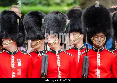 Authentisches Image mit einem Konzept der Vielfalt. Einzelner schwarzer Soldat mit weißen kaukasischen Soldaten der britischen Armee. Ungerade. Die Farbe ins Trooping Stockfoto