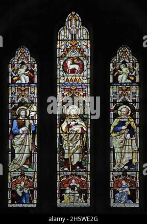 Ein Buntglasfenster, das Jesus, den Guten Hirten, den Heiligen Johannes den Täufer und den Heiligen Petrus, die Heilige Maria und das Heilige Kreuz, Alderminster, Warwickshire, zeigt Stockfoto