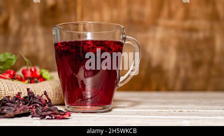 Natürlicher Tee aus wilden Rosenbeeren auf Holzbrettern. Homöopathie Behandlung von roten Beeren. Stockfoto