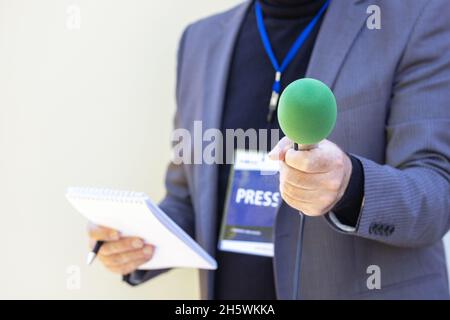 Reporter, der Mikrofon hält und Medieninterview macht Stockfoto