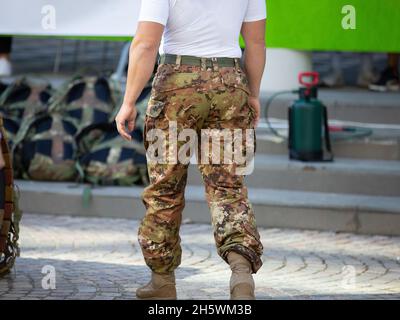 Soldat macht sich bereit für Übungen mit Camouflage Pants und Rucksack auf dem Boden. Stockfoto