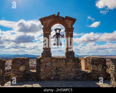 Steinbogen mit einer großen Glocke an der Wand des Schlosses von Trujillo de Cáceres. Stockfoto