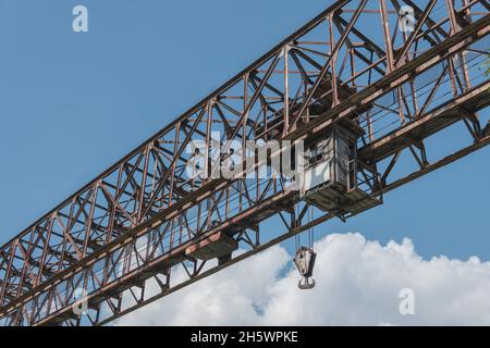 Alt verrostet schwere Portalkran mit massiven Haken und Fahrerhaus gegen blauen Himmel Stockfoto