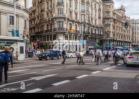 MADRID, SPANIEN - 22. OKTOBER 2017: Straßenverkäufer Rennen vor der Polizei in der Calle Gran Via in Madrid. Stockfoto