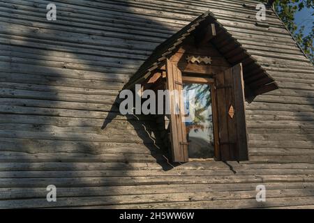 Vintage Fensterläden auf dem Holzdach eines alten Hauses. Stockfoto