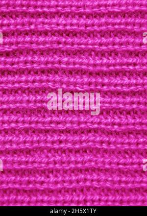 Nahaufnahme der Textur des lebendigen Fuchsia Pink Strickwollmaterials in horizontalen Mustern Stockfoto