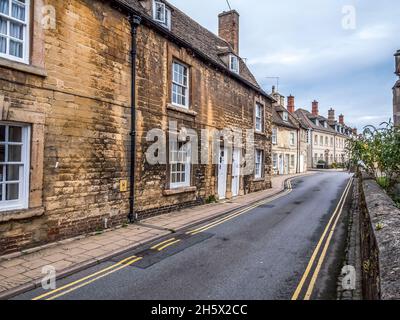 Bunte Straßenszene in der Lincolnshire-Stadt Stamford, die für ihre enge Straße mit buffigen Steingebäuden und georgianischer Architektur berühmt ist Stockfoto