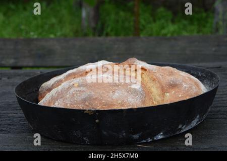 Selektive Fokusaufnahme von frisch Backbrot in einer Pfanne auf einer Holzoberfläche Stockfoto