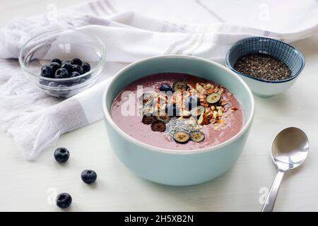 Gesunde, geglättet Schüssel mit Chiasamen, Heidelbeeren, Nüssen und Erdnussbutter. Veganes Frühstück Stockfoto