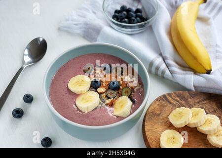 Geglättet mit Banane, Chiasamen, Heidelbeeren, Nüssen und Erdnussbutter. Veganes Frühstück. Draufsicht Stockfoto