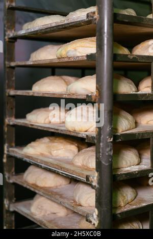 Brotteig auf Metallgestell in der Küche des Backhauses gelegt Stockfoto