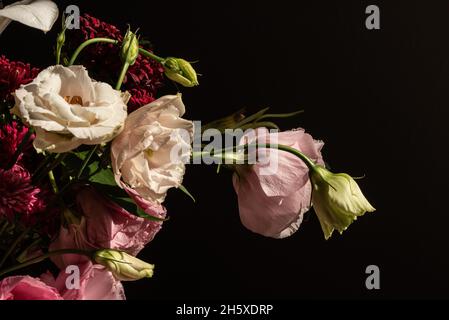 Blumenstrauß mit Rosen und weißen Lilien, bei Sonnenschein in Glasvase Stockfoto