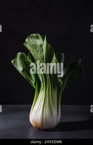 Gesundes frisches Kohl-Kohlblatt-Gemüse auf schwarzem Tisch vor dunklem Hintergrund platziert Stockfoto